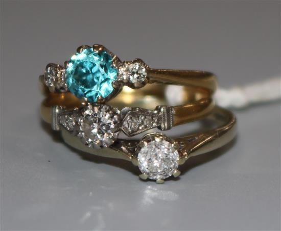 An 18ct gold, blue zircon and diamond three stone ring and two other diamond rings, one 18ct and one 9ct.